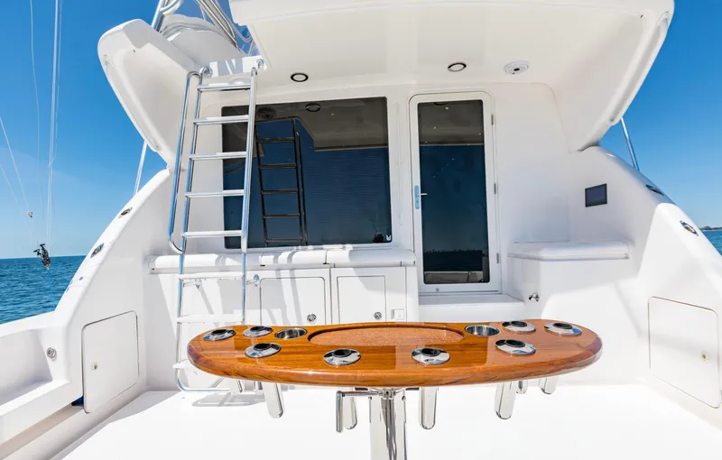  Yacht Photos Pics 2007 Bertram 570 yacht deck with wooden table and ladder, under clear blue sky.