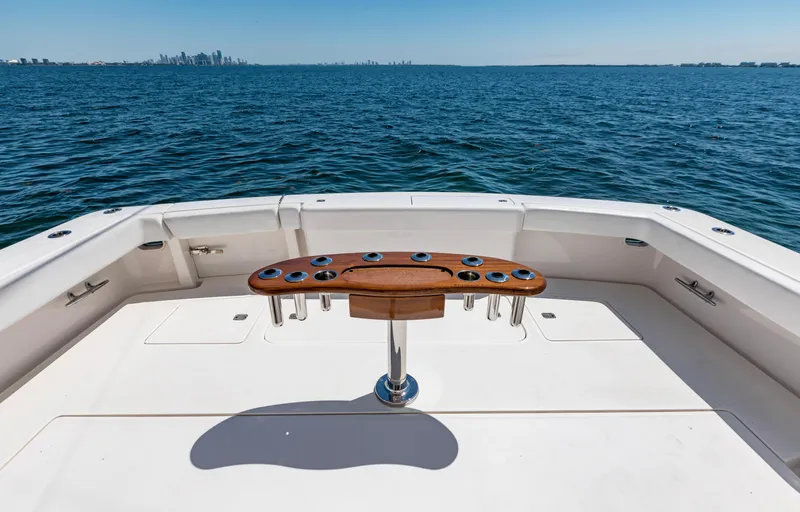  Yacht Photos Pics Bertram 570 yacht deck, 2007 model, overlooking calm ocean waters with city skyline in distance.