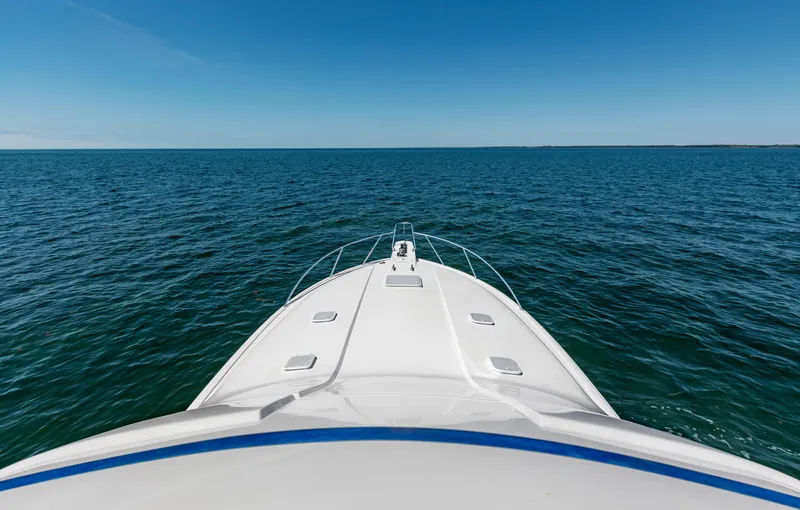 Yacht Photos Pics Bow view of 2007 Bertram 570 yacht cruising on open sea under clear blue sky.