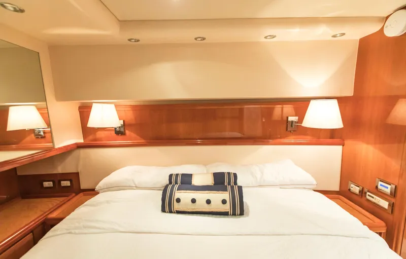  Yacht Photos Pics Luxurious cabin interior of a 2007 Bertram 570 yacht with elegant bedding and warm lighting.