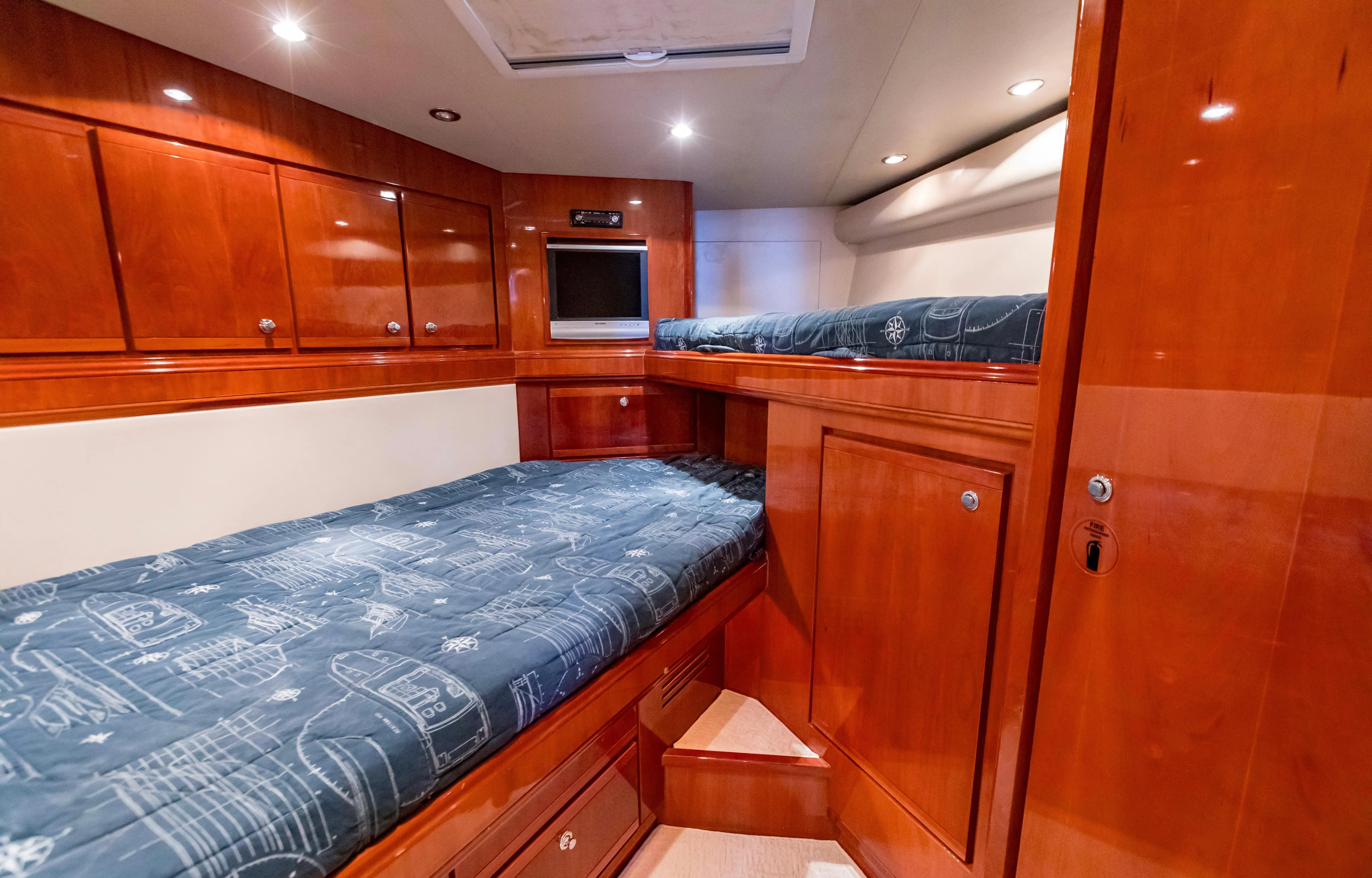  Yacht Photos Pics Luxurious 2007 Bertram 570 yacht cabin with wooden cabinetry and cozy bedding.