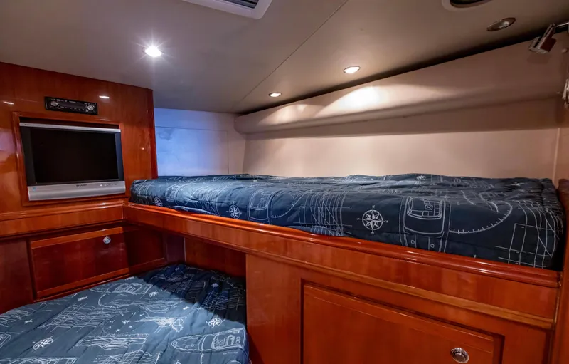  Yacht Photos Pics Luxurious cabin interior of 2007 Bertram 570 yacht with bunk beds and TV.