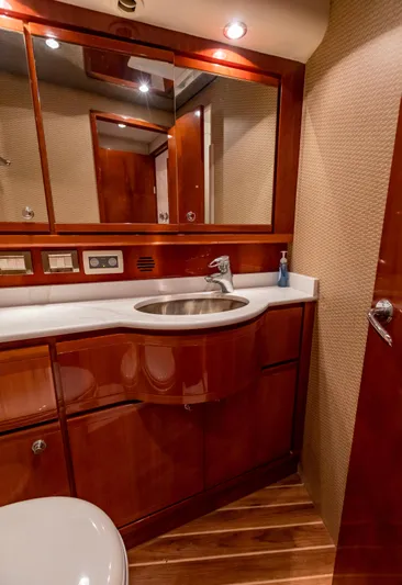  Yacht Photos Pics Luxurious bathroom in a 2007 Bertram 570 yacht with wood accents and modern fixtures.