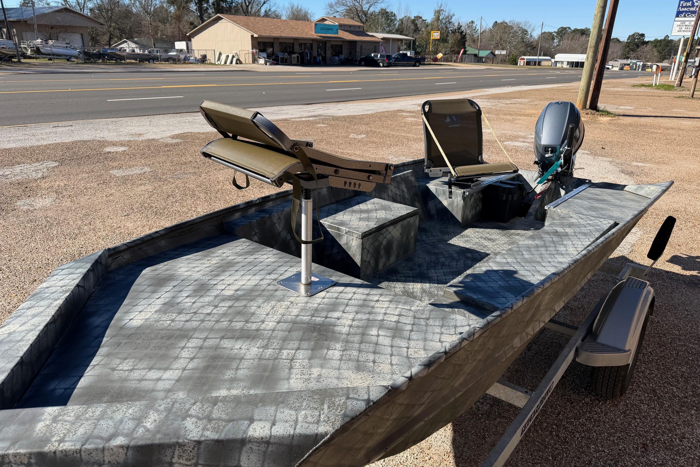 2025 WeldBilt 1448 boat with camouflage design, parked on a trailer near a road.