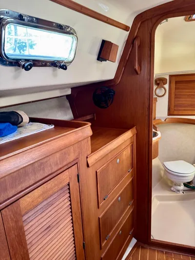 TinteÁn Yacht Photos Pics Interior of 2000 Island Packet 40 sailboat, featuring wooden cabinetry and a compact bathroom.