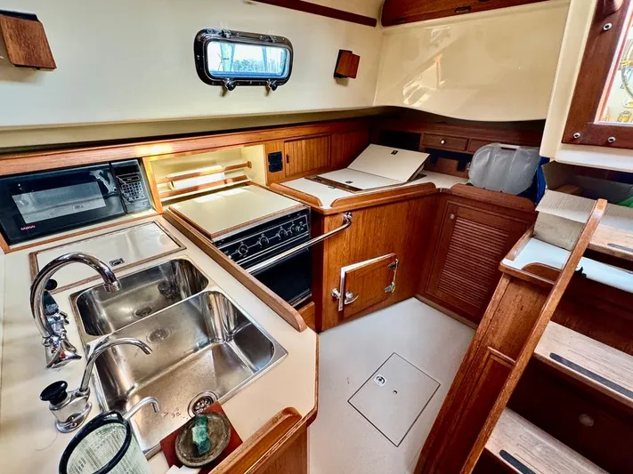 TinteÁn Yacht Photos Pics Island Packet 40 yacht kitchen interior, 2000 model, featuring wood cabinetry and stainless steel sink.