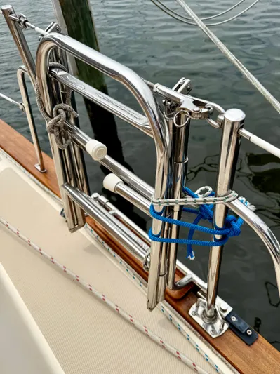 TinteÁn Yacht Photos Pics Stainless steel ladder on 2000 Island Packet 40 sailboat, docked by the water.