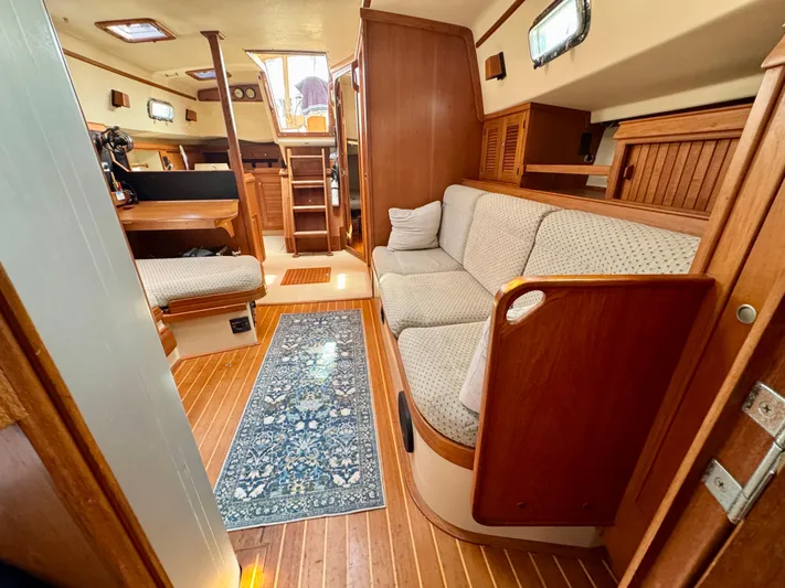 TinteÁn Yacht Photos Pics Interior of 2000 Island Packet 40 sailboat with cozy seating and wooden finishes.