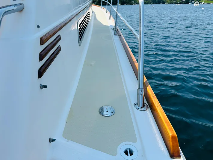 Slipped Away Yacht Photos Pics 2008 Sabre 42 Hardtop Express yacht deck with wooden railings on calm water.
