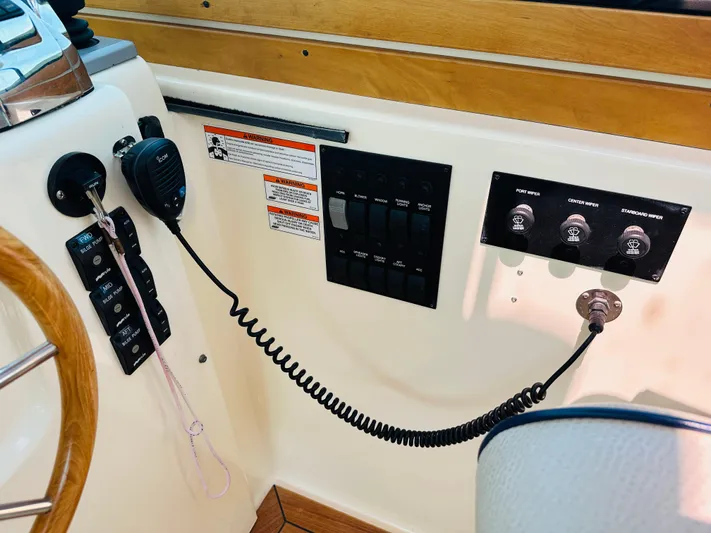 Slipped Away Yacht Photos Pics Control panel of a 2008 Sabre 42 Hardtop Express boat with switches and radio.