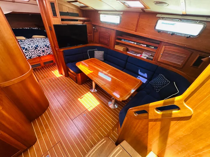Slipped Away Yacht Photos Pics 2008 Sabre 42 Hardtop Express interior with wooden flooring, blue seating, and dining table.
