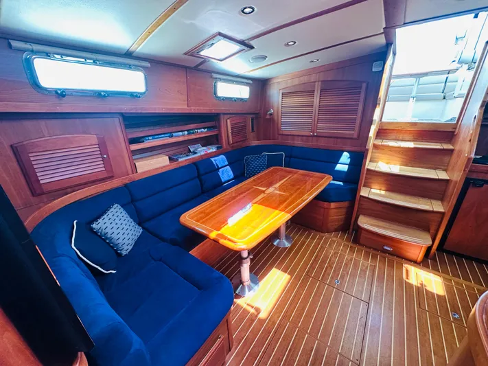 Slipped Away Yacht Photos Pics 2008 Sabre 42 Hardtop Express interior with wooden table, blue seating, and stairs.