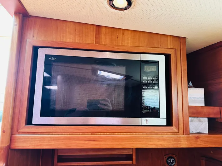 Slipped Away Yacht Photos Pics Microwave in 2008 Sabre 42 Hardtop Express yacht kitchen, wooden cabinetry.