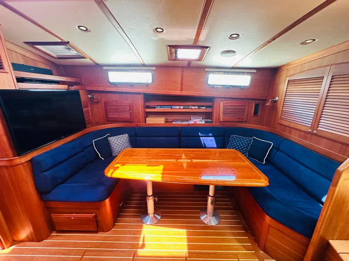 Slipped Away Yacht Photos Pics Luxurious interior of 2008 Sabre 42 Hardtop Express with wooden table and blue seating.