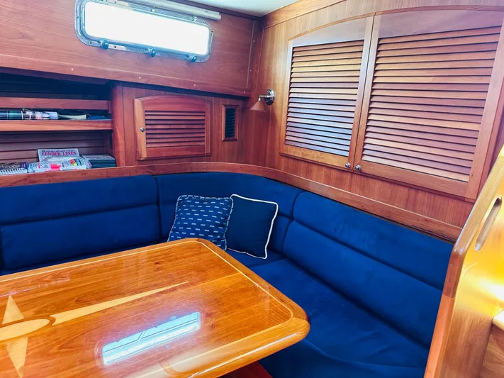 Slipped Away Yacht Photos Pics 2008 Sabre 42 Hardtop Express interior with blue seating, wooden table, and storage cabinets.