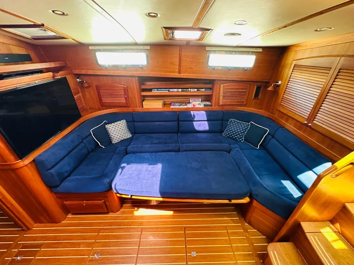 Slipped Away Yacht Photos Pics Luxurious interior of 2008 Sabre 42 Hardtop Express with blue seating and wooden accents.