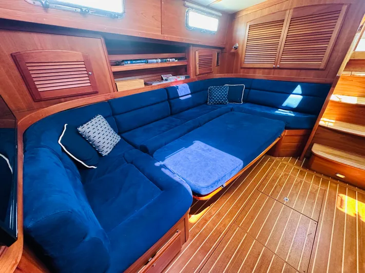 Slipped Away Yacht Photos Pics Luxurious interior of 2008 Sabre 42 Hardtop Express with blue seating and wooden accents.