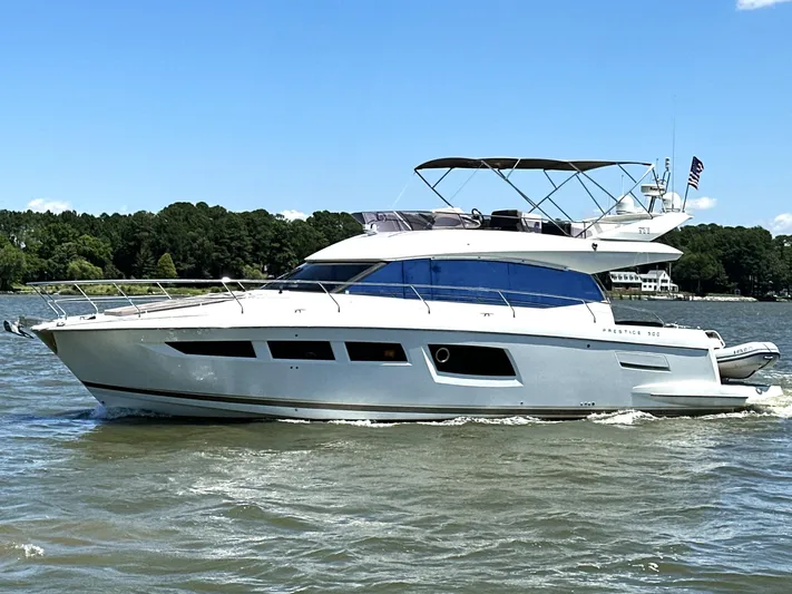  Yacht Photos Pics 2017 Prestige 500 yacht cruising on a sunny day, surrounded by lush greenery.