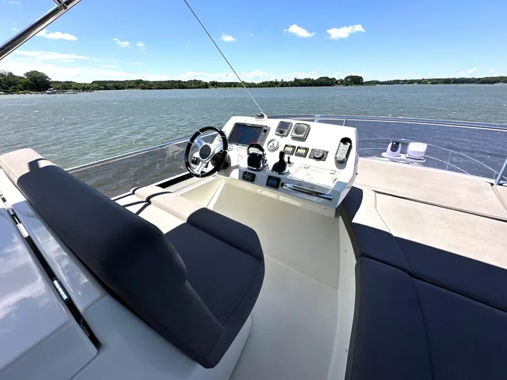  Yacht Photos Pics Flybridge of 2017 Prestige 500 yacht with helm station overlooking serene waters.
