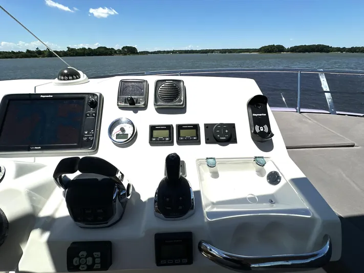  Yacht Photos Pics Control panel of a 2017 Prestige 500 yacht with navigation equipment, overlooking a serene water view.
