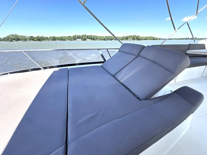  Yacht Photos Pics Luxurious sunbed on 2017 Prestige 500 yacht, overlooking serene waters and lush shoreline.