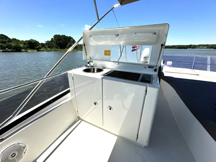  Yacht Photos Pics 2017 Prestige 500 yacht with outdoor kitchenette on deck, featuring sink and grill.