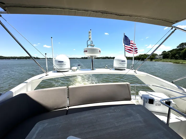  Yacht Photos Pics Luxurious 2017 Prestige 500 yacht cruising on a serene lake under a clear blue sky.