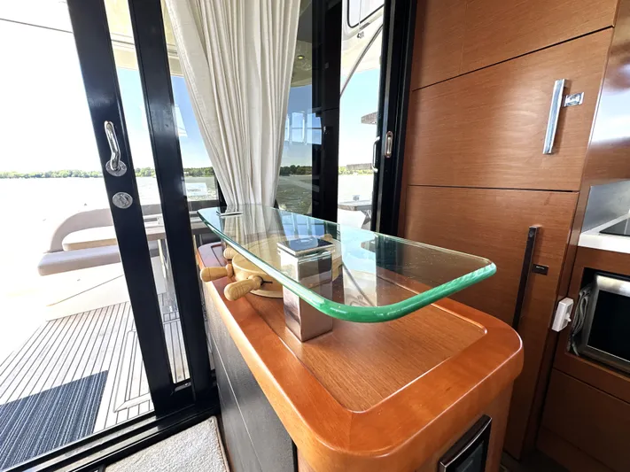  Yacht Photos Pics Luxurious interior of 2017 Prestige 500 yacht with glass table and wooden accents.