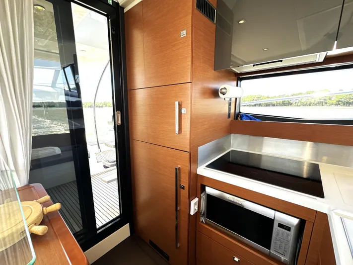  Yacht Photos Pics Modern kitchen interior on a 2017 Prestige 500 yacht, featuring sleek wood cabinetry and appliances.
