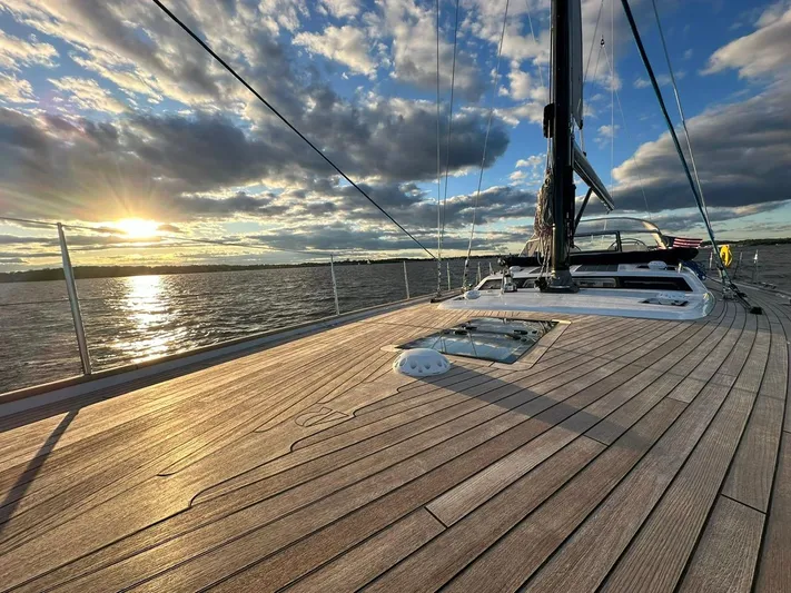 Pinnacle Yacht Photos Pics 2023 Hallberg-Rassy 57 yacht deck at sunset, sailing on calm waters.