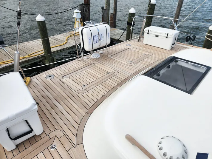 Pinnacle Yacht Photos Pics 2023 Hallberg-Rassy 57 yacht deck with wooden finish, docked at a marina.