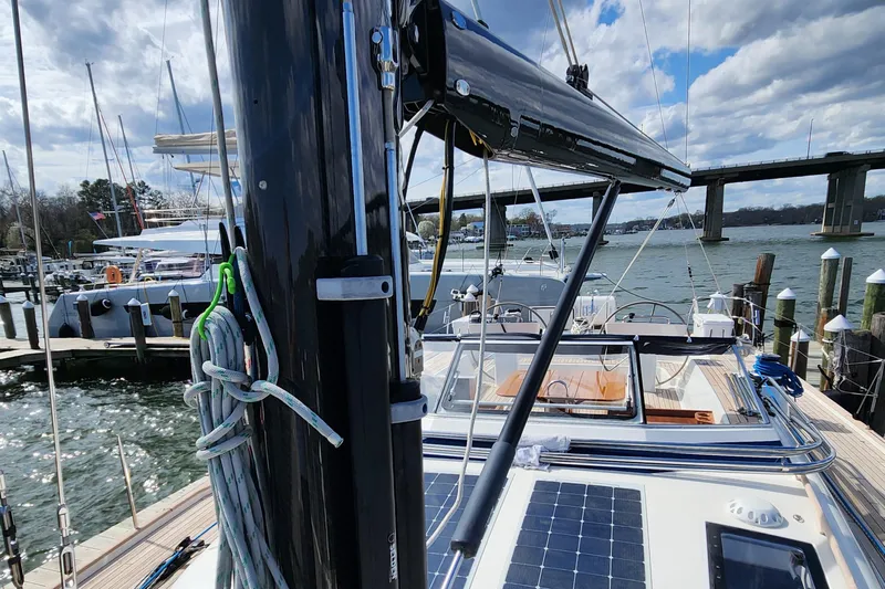 Pinnacle Yacht Photos Pics 2023 Hallberg-Rassy 57 yacht docked, showcasing deck and solar panels under a cloudy sky.