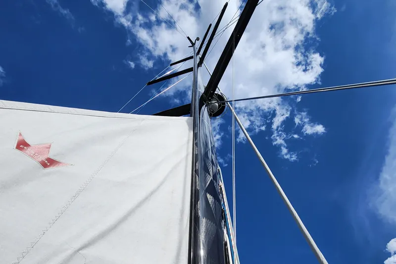 Pinnacle Yacht Photos Pics Hallberg-Rassy 57 sailboat mast and sail against a blue sky, 2023 model.