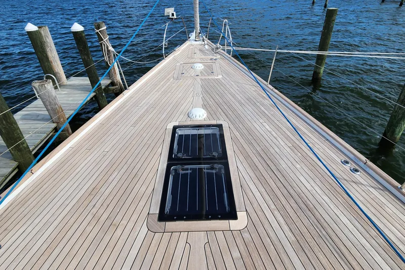 Pinnacle Yacht Photos Pics 2023 Hallberg-Rassy 57 yacht deck with wooden finish, docked at a marina.