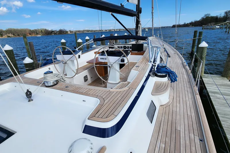 Pinnacle Yacht Photos Pics 2023 Hallberg-Rassy 57 yacht with wooden deck, docked by the water.