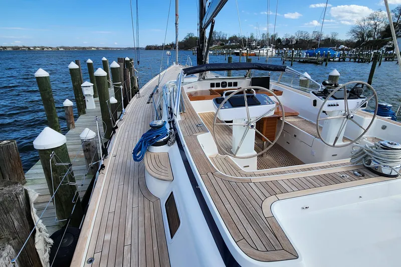 Pinnacle Yacht Photos Pics 2023 Hallberg-Rassy 57 yacht docked, showcasing elegant deck and dual steering wheels.