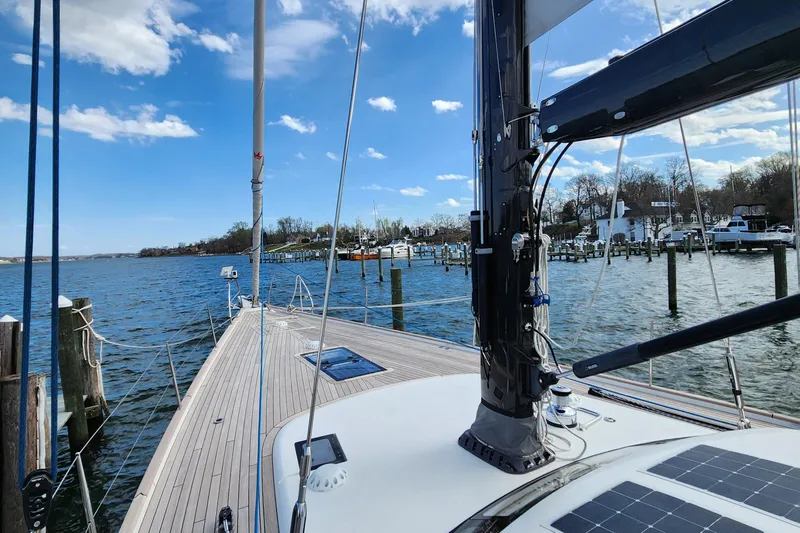 Pinnacle Yacht Photos Pics 2023 Hallberg-Rassy 57 yacht docked, showcasing sleek deck and mast under blue sky.