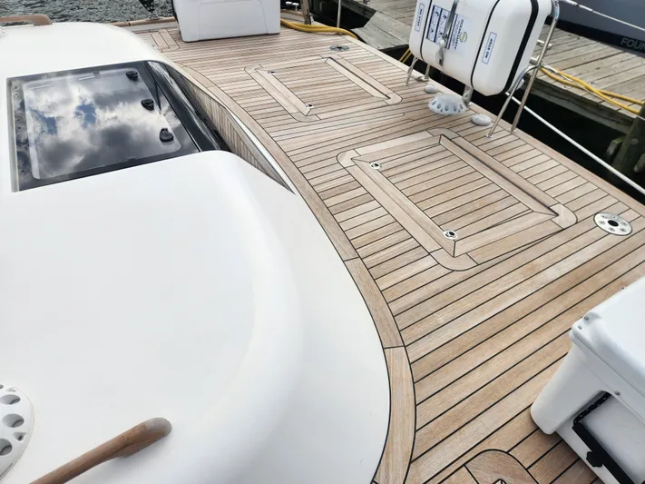 Pinnacle Yacht Photos Pics 2023 Hallberg-Rassy 57 yacht deck with teak wood finish and safety equipment.