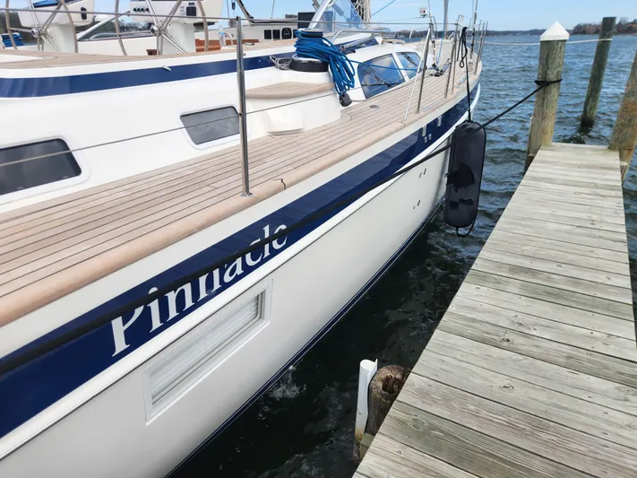Pinnacle Yacht Photos Pics 2023 Hallberg-Rassy 57 yacht docked, featuring sleek design and wooden deck.