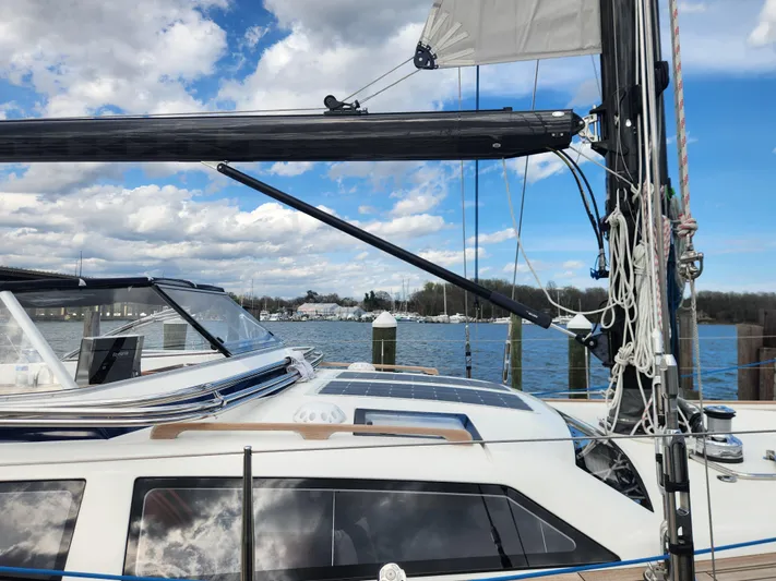 Pinnacle Yacht Photos Pics 2023 Hallberg-Rassy 57 yacht docked, showcasing sleek design and modern rigging against a scenic waterfront.