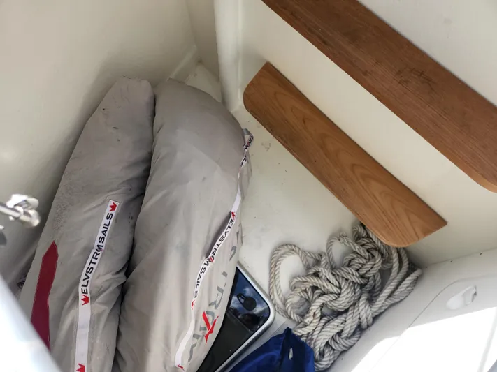 Pinnacle Yacht Photos Pics Storage area on a 2023 Hallberg-Rassy 57 yacht with sails and coiled rope.