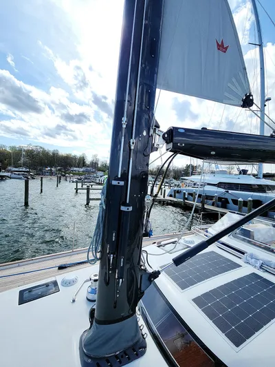 Pinnacle Yacht Photos Pics 2023 Hallberg-Rassy 57 yacht with solar panels and mast, docked at a marina.