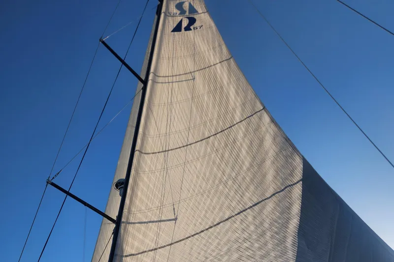 Pinnacle Yacht Photos Pics Sail of 2023 Hallberg-Rassy 57 yacht against clear blue sky.