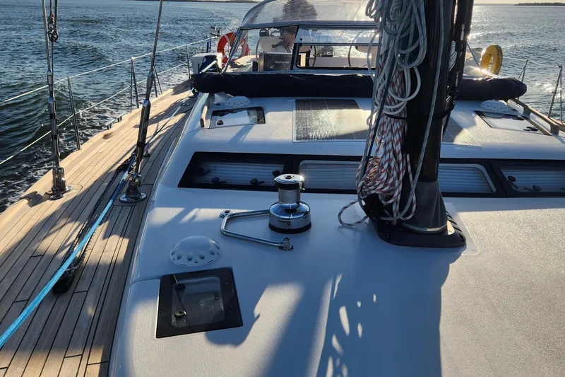 Pinnacle Yacht Photos Pics 2023 Hallberg-Rassy 57 sailboat deck with winch and ropes, sailing on open water.