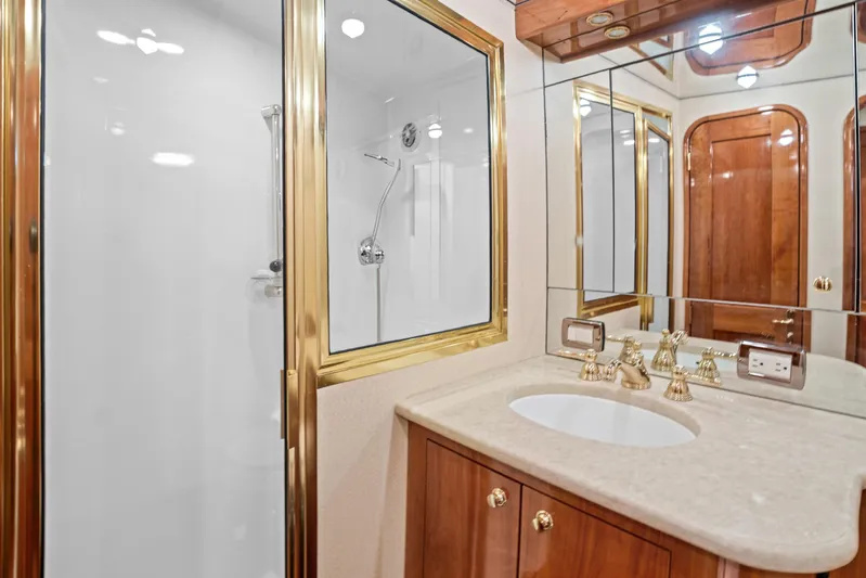 Let's Ride Yacht Photos Pics Luxurious bathroom in 2004 Sculley Custom Carolina 58' Sportfish yacht with gold fixtures and mirrored cabinets.