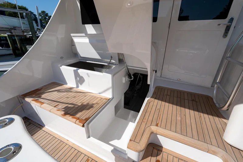 Let's Ride Yacht Photos Pics 2004 Sculley Custom Carolina 58' Sportfish boat deck with teak flooring and storage compartments.