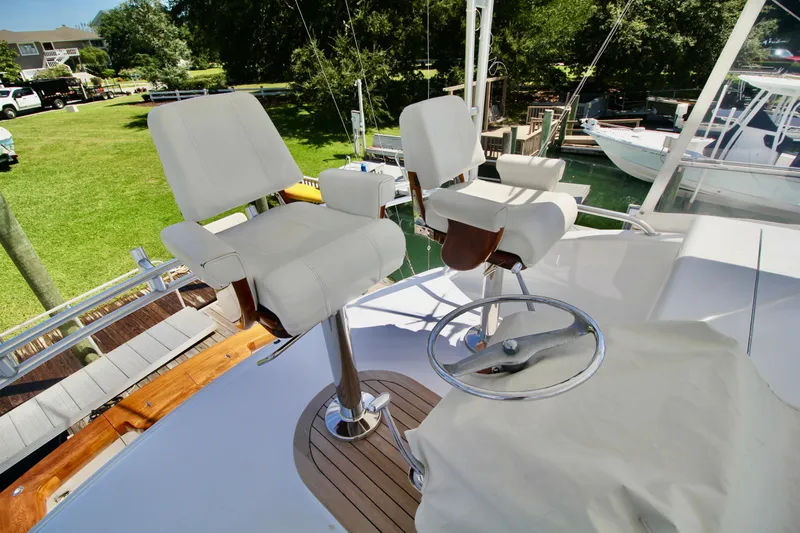 Let's Ride Yacht Photos Pics 2004 Sculley Custom Carolina 58' Sportfish helm with white captain chairs and steering wheel.