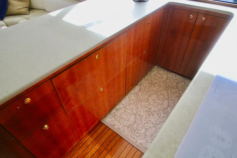 Let's Ride Yacht Photos Pics Interior of 2004 Sculley Custom Carolina 58' Sportfish with wooden cabinetry and patterned rug.