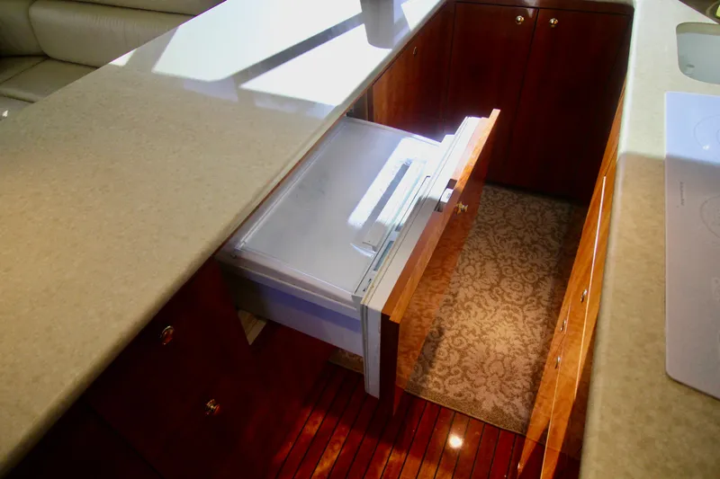 Let's Ride Yacht Photos Pics Interior of 2004 Sculley Custom Carolina 58' Sportfish with open drawer and elegant wood finish.