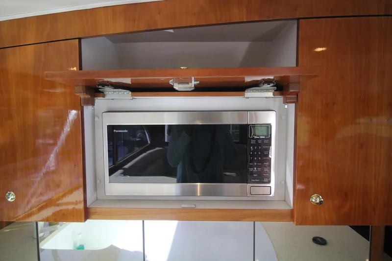 Let's Ride Yacht Photos Pics Built-in microwave in Sculley Custom Carolina 58' Sportfish yacht, 2004 model, with wooden cabinetry.